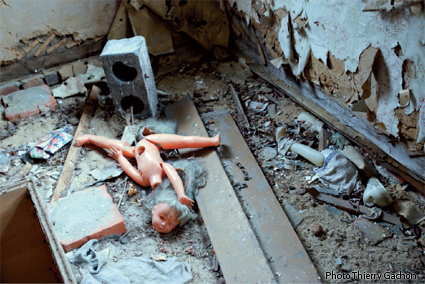 Photo d'une poupée cassée dans une maison abandonnée.