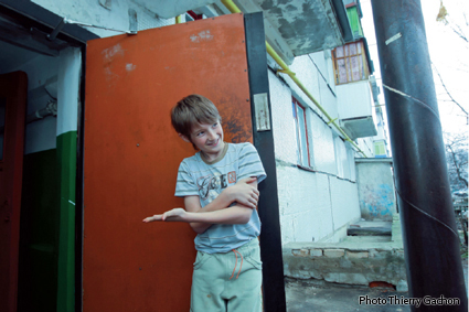 Photo de Serguei, 10 ans, faisant signe de rentrer dans son HLM.